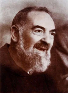 Ritratto fotografico di Padre Pio sorridente, con la barba bianca e il saio da cappuccino