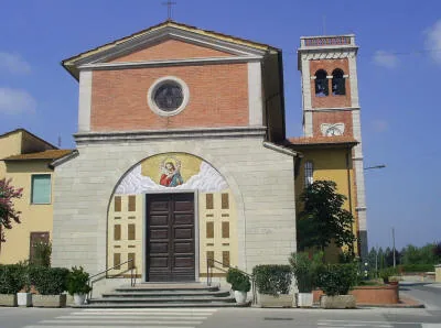 Facciata della chiesa di San Pietro d’Alcantara a Villa Campanile, in mattoni e pietra chiara, con il mosaico del Buon Pastore sopra il portale e il campanile a destra